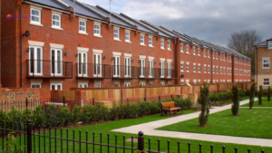 Image of a row of modern, brick townhouses with well-maintained gardens and walkways, representing the type of property that may be considered by company directors seeking a mortgage. 