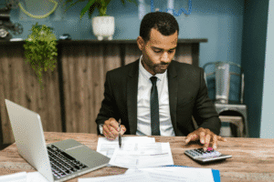 Landlord working on ICR calculations with a calculator and financial documents