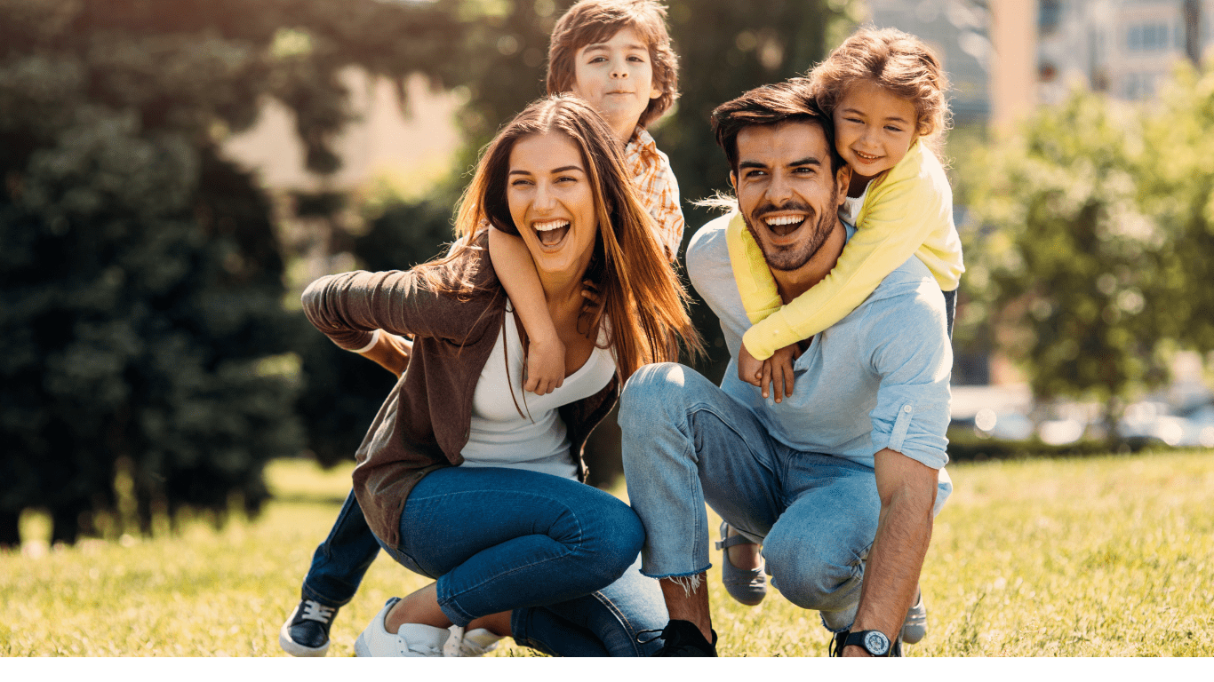 Smiling family enjoying time outdoors, representing the security mortgage protection provides for a happy, stable future.