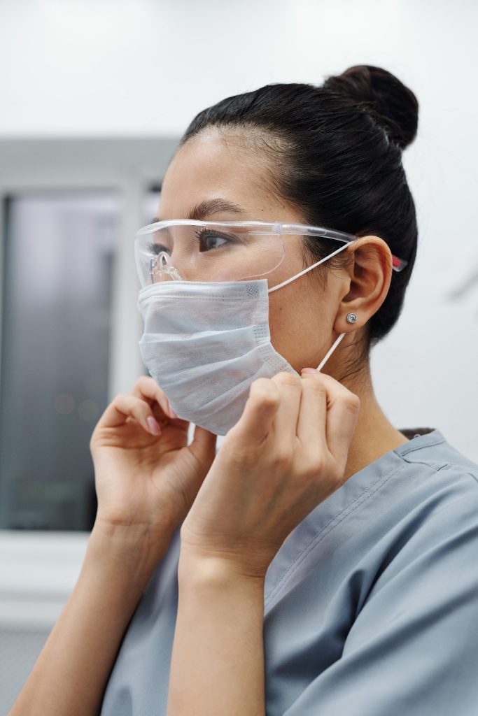 Nurse putting on her PPE to treat a critically ill patient.