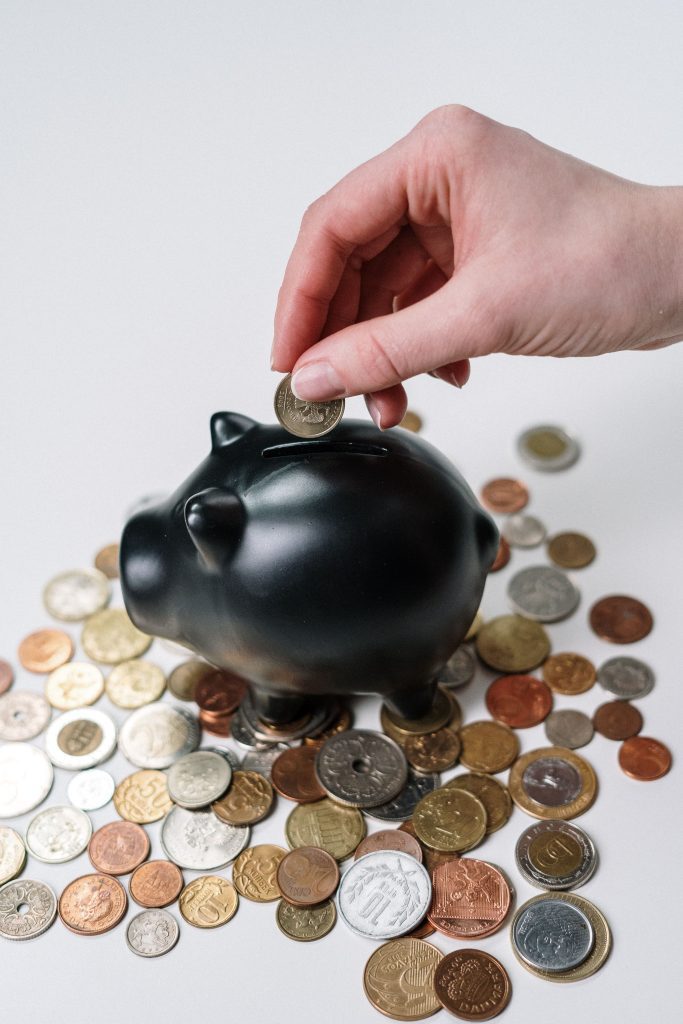 Person protecting their money by saving it in a piggy bank.