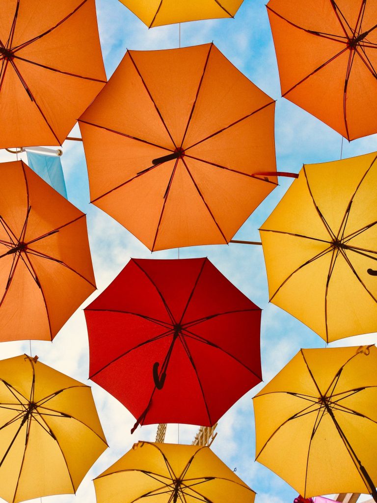 A variety of umbrellas in different colours, which is commonly used in Financial Services to depict protection.