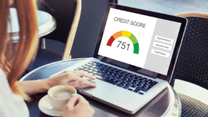 Person checking their credit score on a laptop, showing a score of 751 with payment history and credit details.