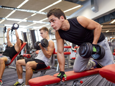 Gym members lifting weights during a strength training session, highlighting the importance of sports injury insurance for active lifestyles and fitness enthusiasts.