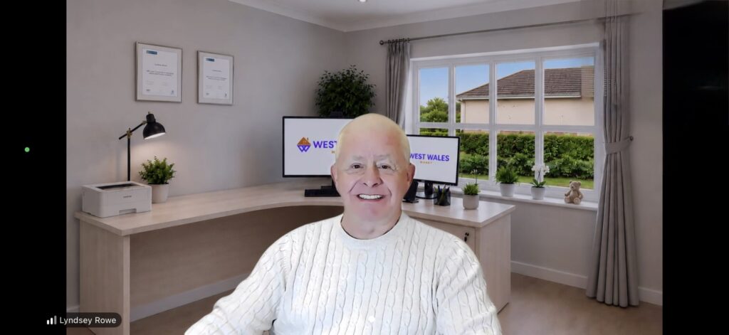 Lyndsey Rowe, Mortgage & Protection Adviser at West Wales Money, in his home office during a video consultation with dual monitors displaying the West Wales Money logo.